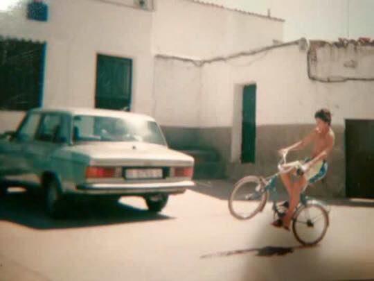 Joven haciendo un caballito en bicicleta en una calle