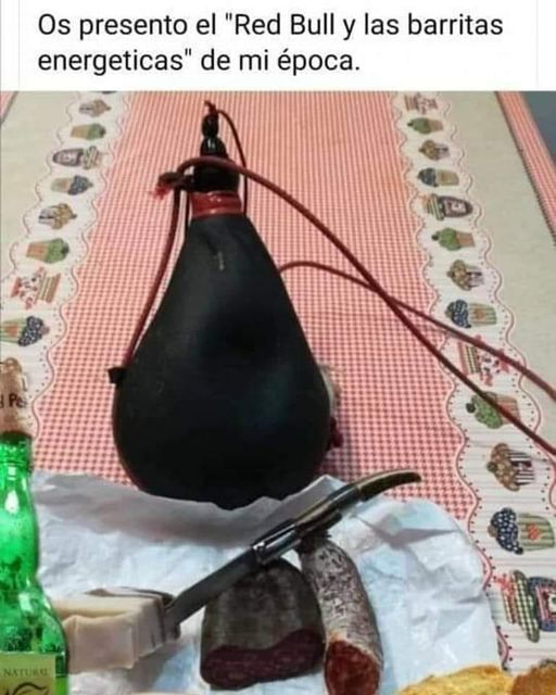 Bota de vino negra sobre un mantel de cuadros rojos junto a chorizo, salchichón y una navaja.