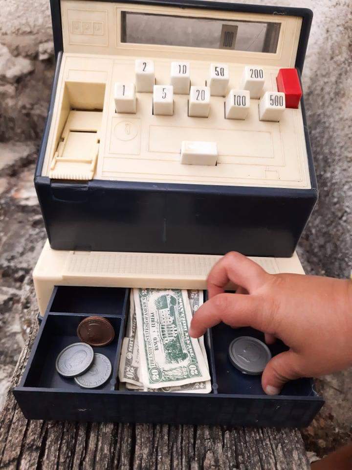 Caja registradora de juguete con billetes y monedas.