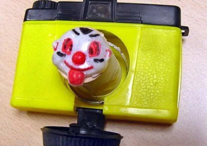 Cámara de juguete amarilla con payaso.