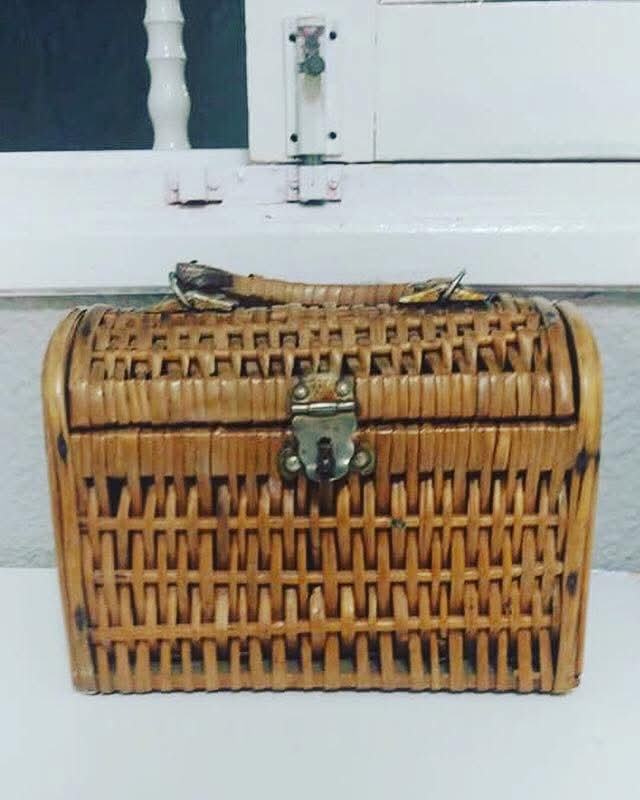 Cesta de mimbre con asa y cierre metálico.