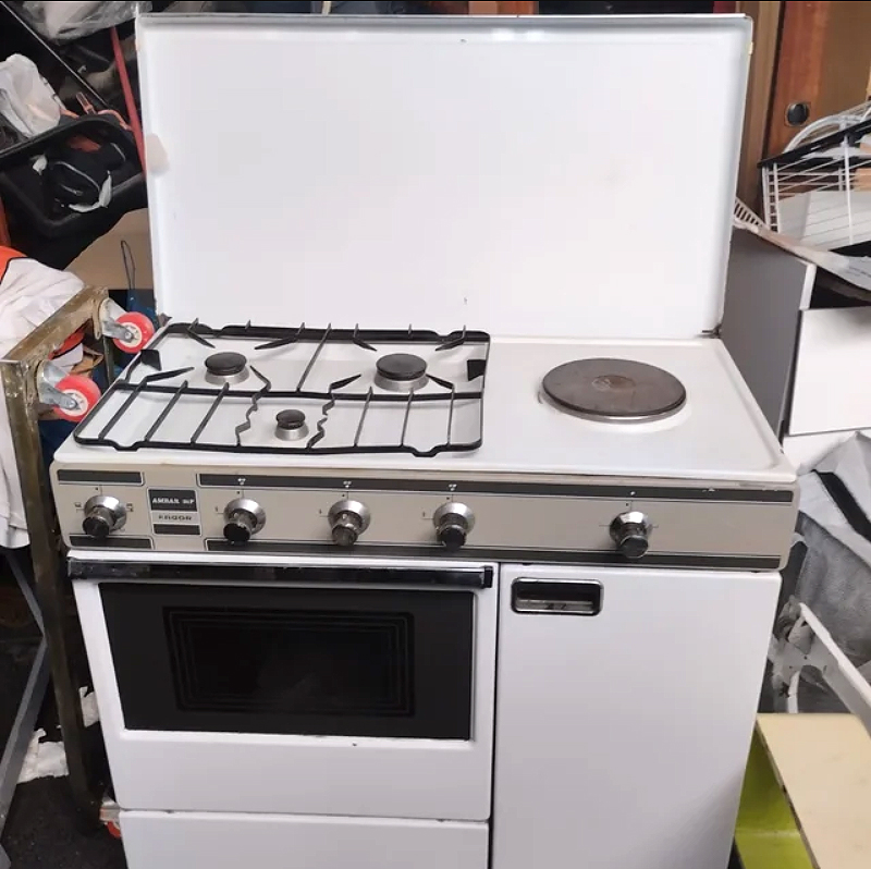 Cocina blanca de gas con horno y placa eléctrica