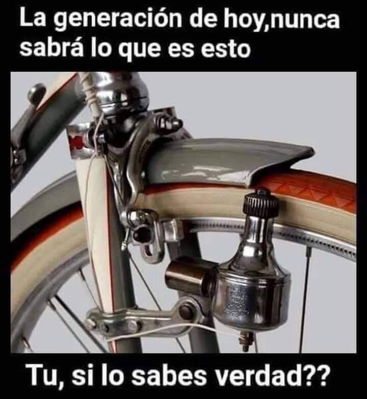 Dinamo metálica de bicicleta apoyada en la rueda delantera junto al guardabarros.