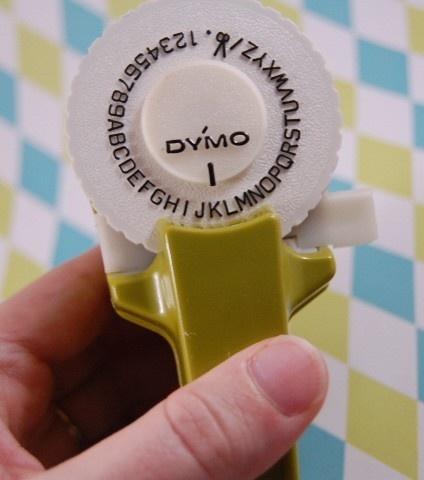 Etiquetadora Dymo con la rueda de letras en una mano