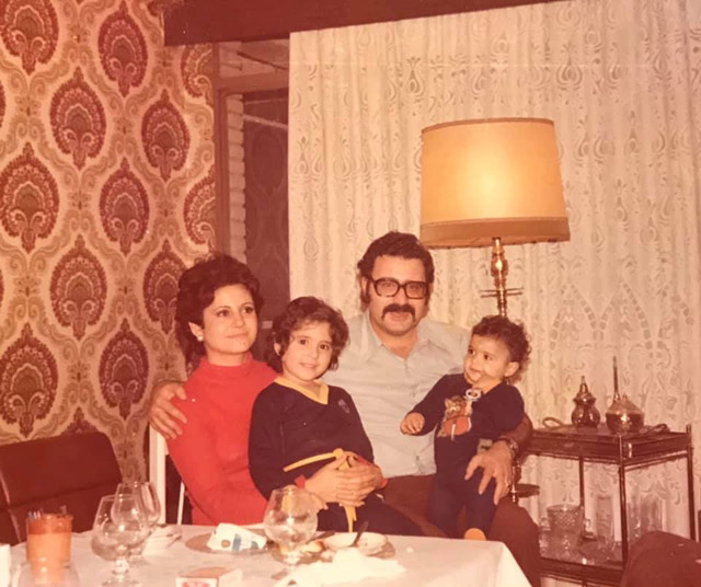 Familia posando en un salón con papel pintado
