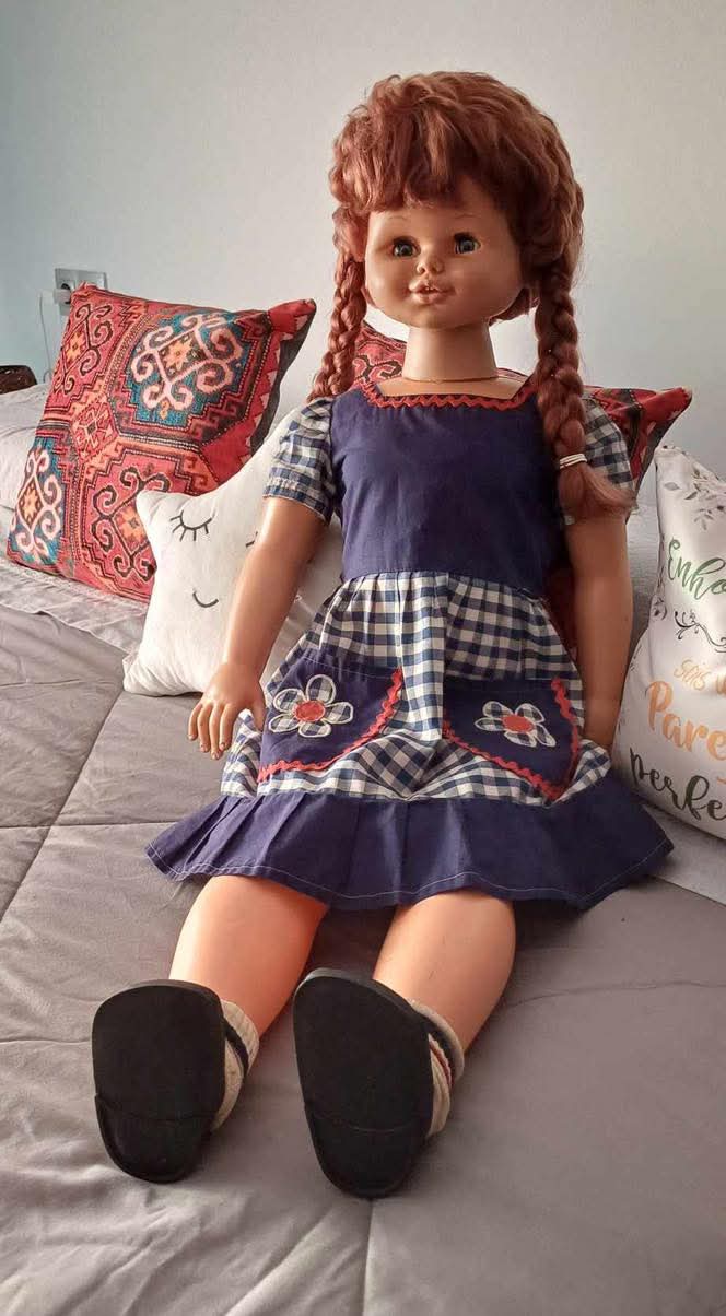 Muñeca grande de pelo pelirrojo con trenzas y vestido de cuadros.