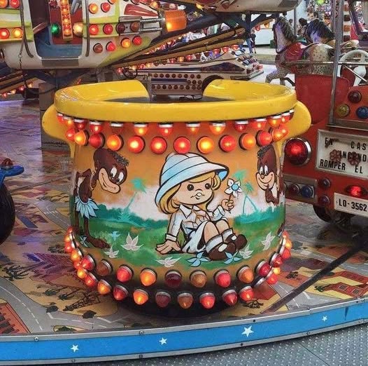 Atracción de feria con forma de olla gigante decorada con dibujos.