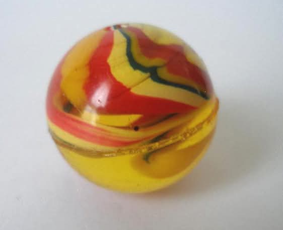 Pelota saltarina de goma amarilla y roja.