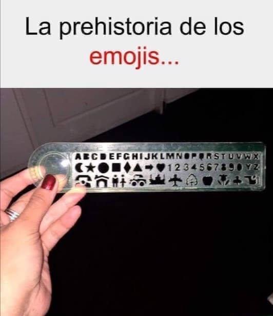 Mano sujetando una regla-plantilla de plástico con letras, números y símbolos recortados.