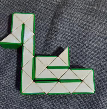 Serpiente de Rubik verde y blanca doblada.