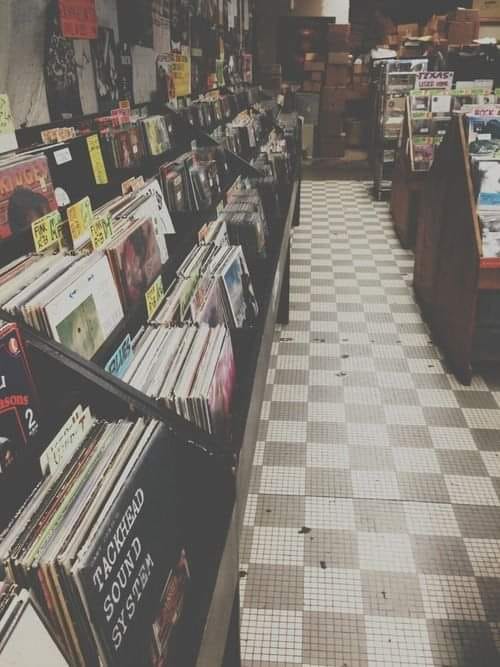 Pasillo de una tienda de discos con estanterías llenas de vinilos.