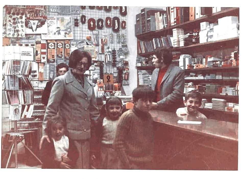 Familia en una tienda antigua con estanterías llenas de productos