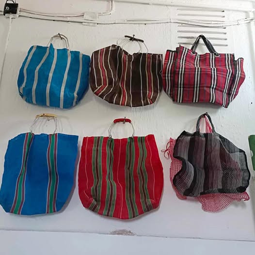 Seis bolsas de tela a rayas colgadas en la pared.