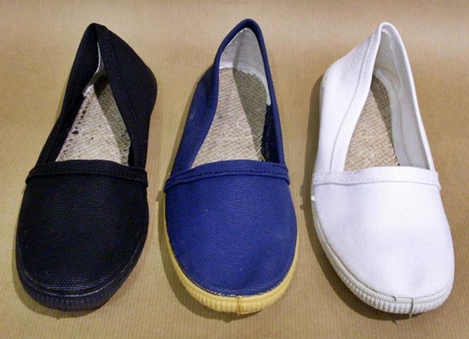 Tres zapatillas Camping de lona negra, azul y blanca.