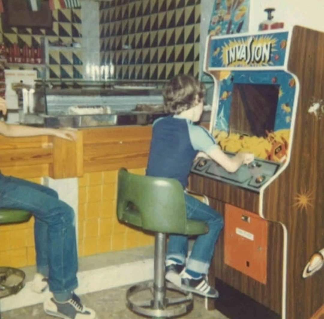 Niños jugando en máquinas recreativas en un bar