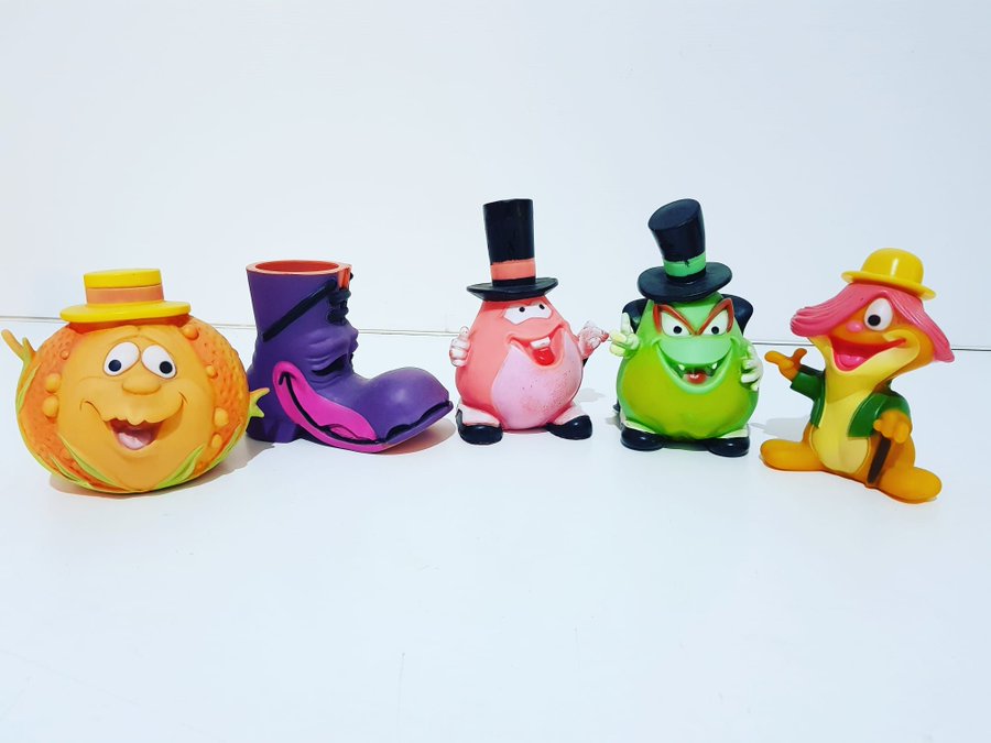 Cinco muñecos de goma de colores: una calabaza, una bota y otros personajes con sombrero.