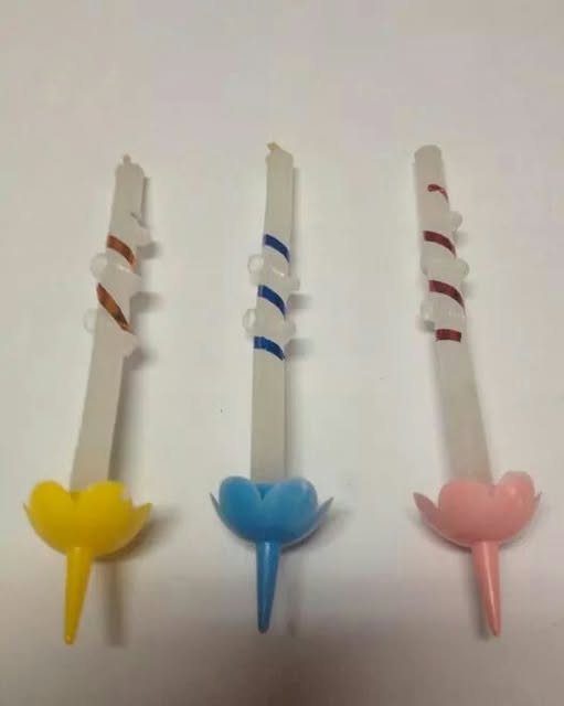 Tres velas de cumpleaños en espiral con base de flor.