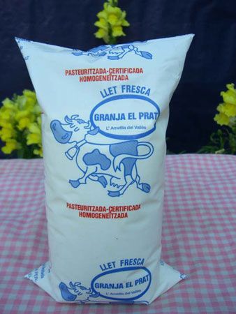 Bolsa de leche fresca Granja El Prat con una vaca dibujada.