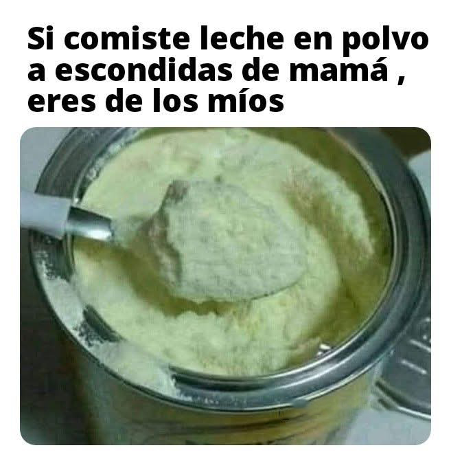 Bote de leche en polvo abierto con una cuchara llena de polvo.