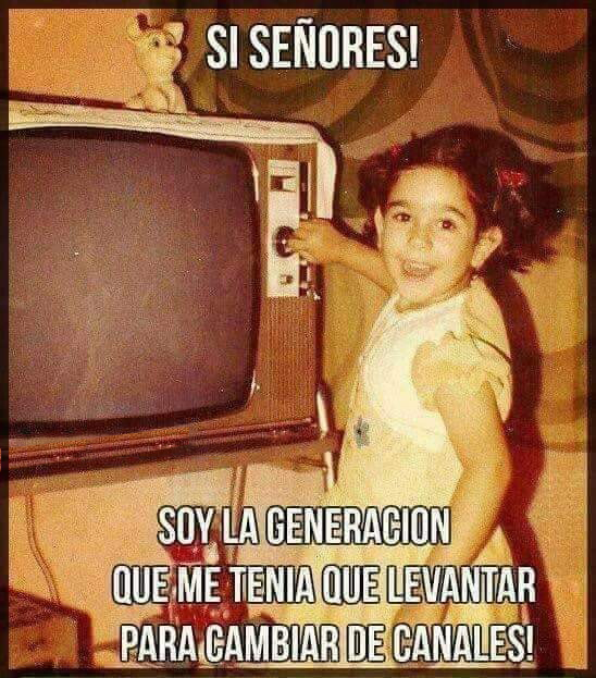 Foto antigua de una niña sonriendo mientras gira el botón de canales de un televisor.