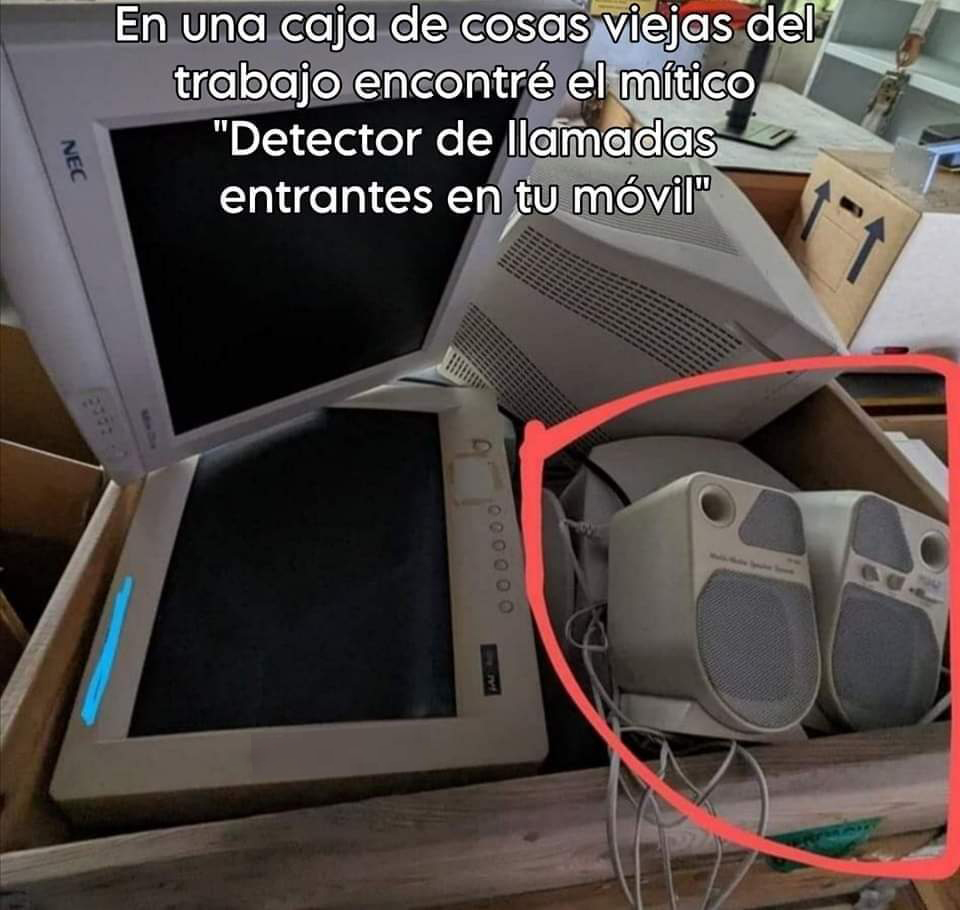 Caja con monitores viejos y dos altavoces de ordenador de color beige señalados con un círculo rojo.