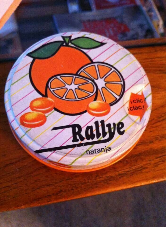 Lata redonda de caramelos Rallye de naranja con el dibujo de una naranja y caramelos.