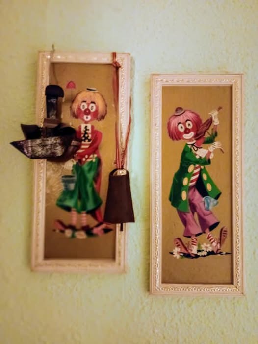 Dos cuadros de payasos colgados en una pared