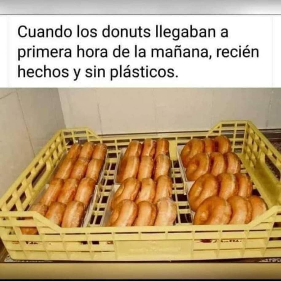 Caja de plástico amarilla de reparto llena de donuts glaseados colocados en filas.