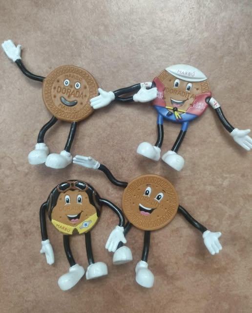 Cuatro muñecos de plástico con forma de galleta Marbú Dorada y brazos y piernas flexibles.