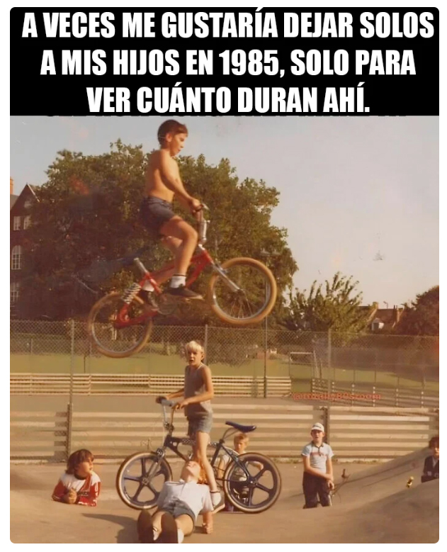 Niño saltando con una bici BMX roja por encima de otro niño tumbado en el suelo mientras otros niños miran, en una foto antigua de colores apagados.