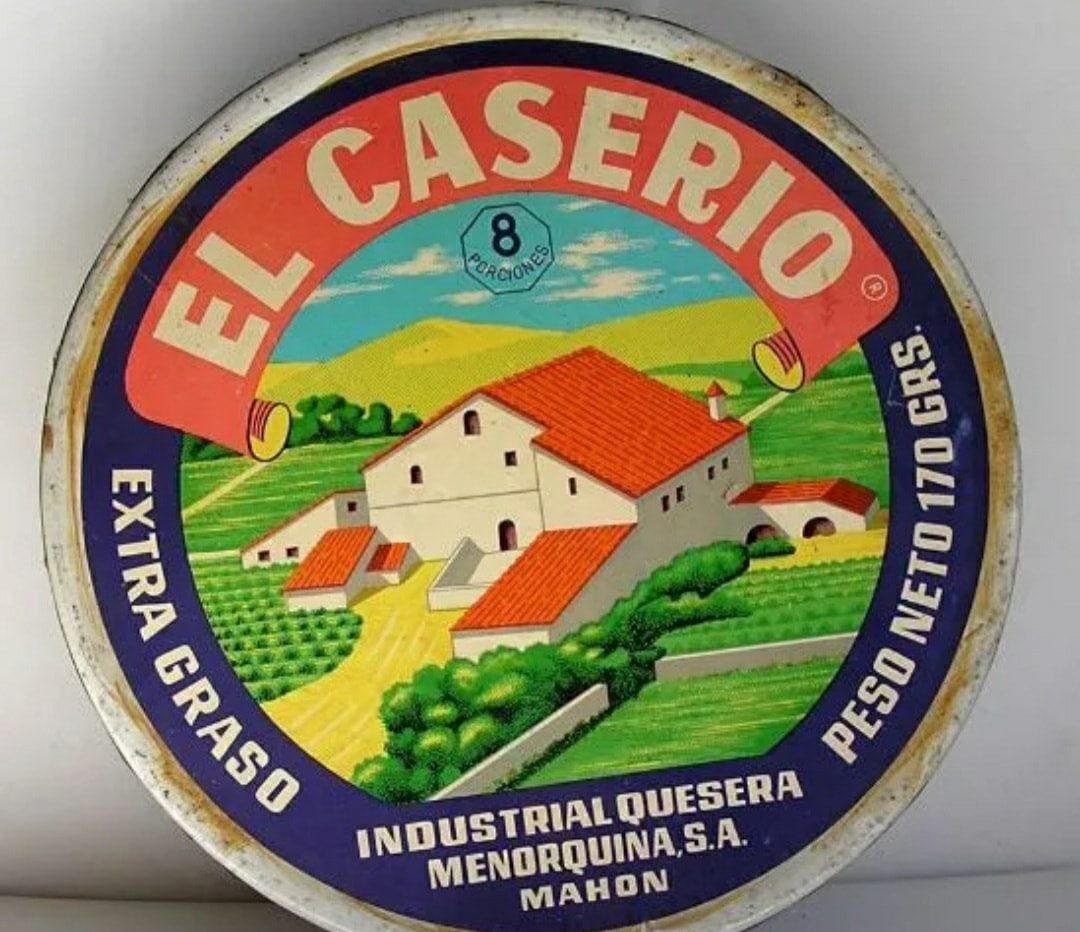 Tapa redonda de la caja de quesitos El Caserío con una casa de campo dibujada.