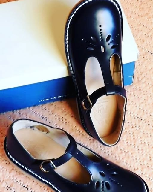 Zapatos negros de niña con hebilla.