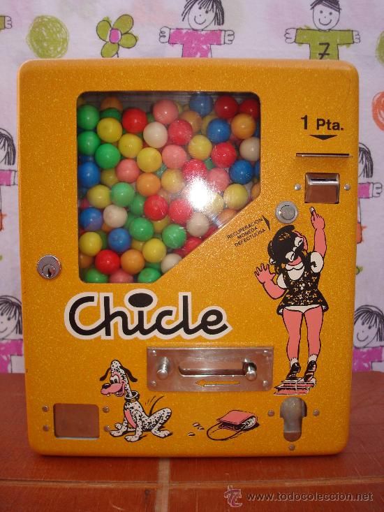 Máquina amarilla de chicles de bola de una peseta con dibujos.