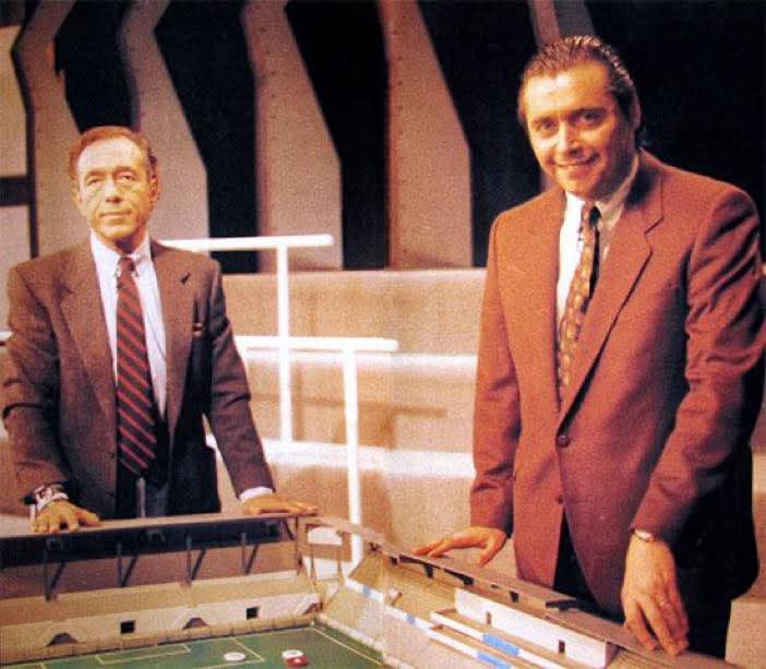 Dos presentadores junto a un futbolín de táctica en un plató