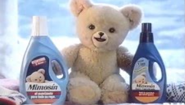 Oso de peluche Mimosín junto a dos botellas de suavizante Mimosín.