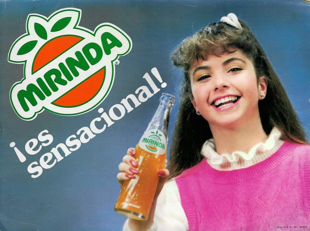 Cartel antiguo de Mirinda con una chica sonriente que sostiene una botella de refresco de naranja.