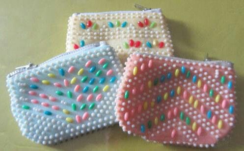 Tres monederos de bolitas de plástico de colores.