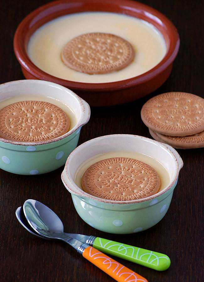 Tres cuencos de natillas con una galleta María encima.
