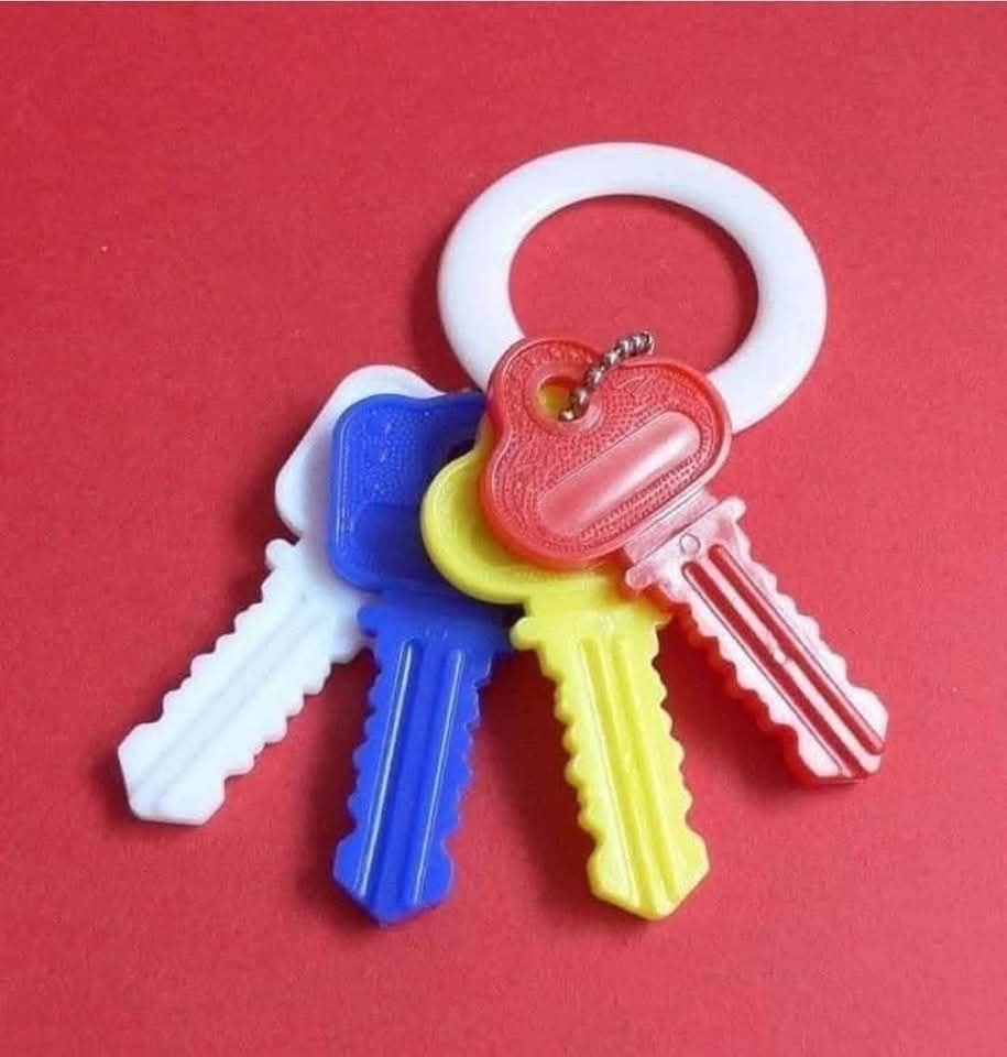 Llavero de juguete para bebés con cuatro llaves de plástico de colores y una anilla blanca.