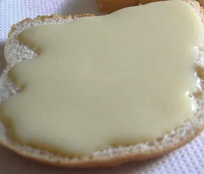 Rebanada de pan con leche condensada untada.