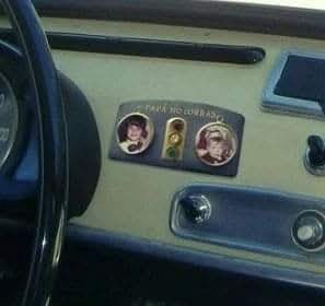 Placa con fotos de niños y el texto Papá no corras en el salpicadero de un coche