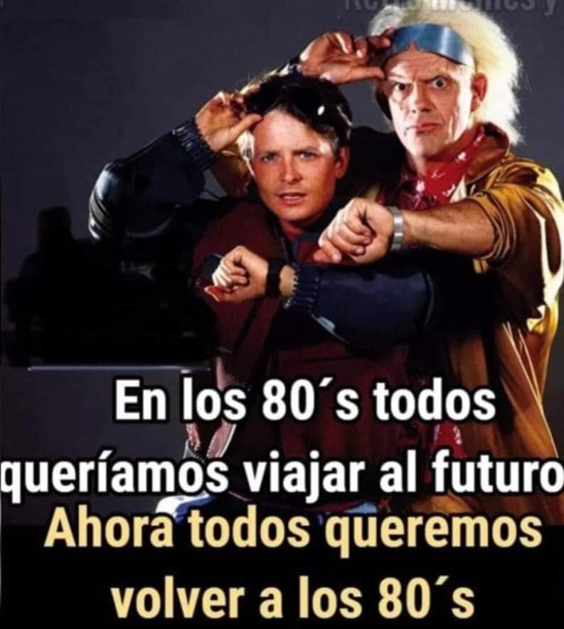 Marty McFly y Doc Brown mirando sus relojes en una foto promocional de Regreso al futuro.