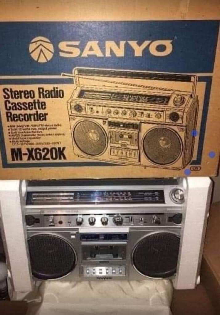 Radiocasete Sanyo plateado junto a su caja.
