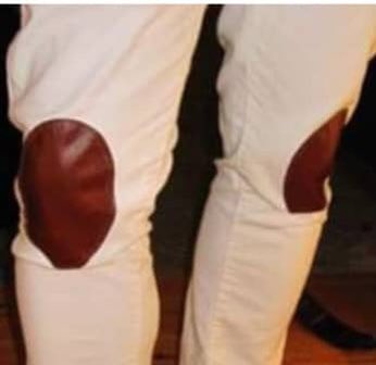 Pantalón blanco con rodilleras de cuero marrón.