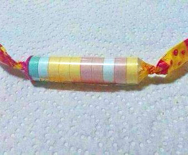 Rollo de pastillas de caramelo de colores pastel envuelto en papel.