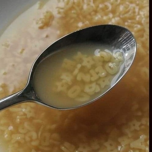 Cuchara con sopa de letras de pasta sobre el plato.