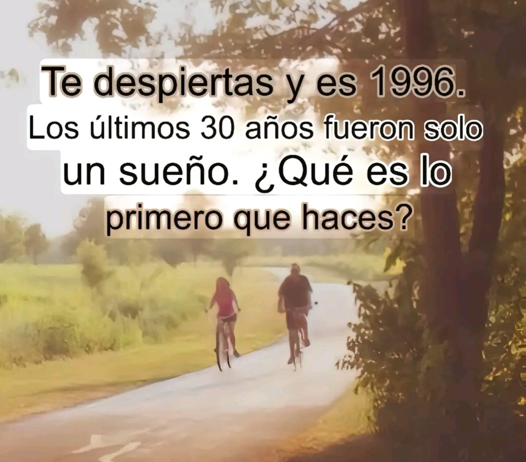 Dos personas montando en bicicleta por un camino entre árboles con luz de atardecer.