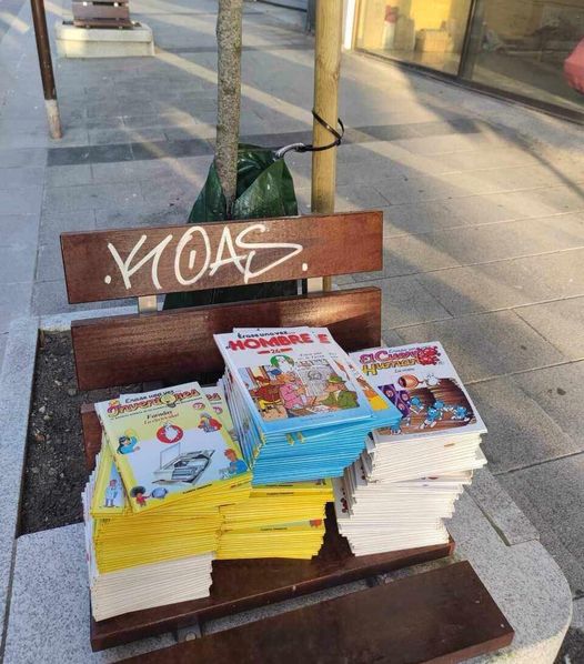 Montón de tebeos sobre un banco de la calle.
