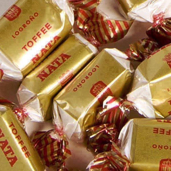 Montón de caramelos toffee de nata Logroño con envoltorio dorado y rojo.