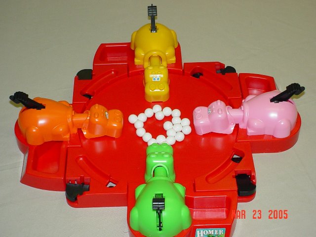 Juego de mesa Tragabolas con cuatro hipopótamos de colores.